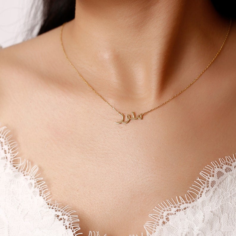Custom Arabic Name Necklace,Arabic Name Necklace,Arabic Necklace, Muslim Girl Necklace.A Dainty Arabic Name Necklace. The necklace is shown on the neck of a woman.Arabic Name by Gold Plated, Sterling Silver Chain.